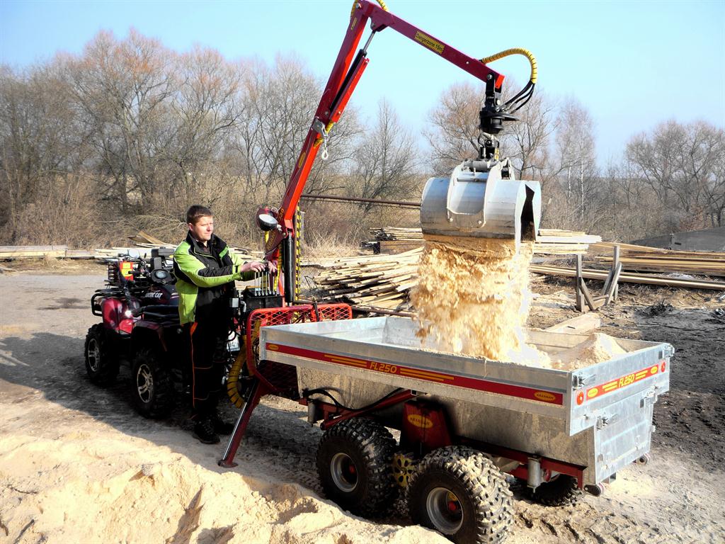 Hydraulická ruka s drapákem nakládá sypký materiál na přívěs Kranman za čtyřkolkou