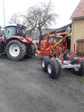 Traktor s vyvážecím přívěsem Kranman na dvoře